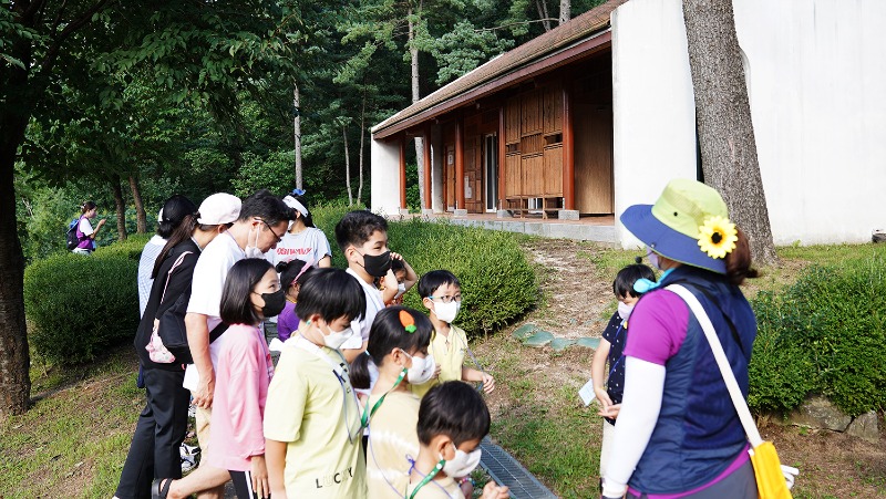 다문화 가족들이 베트남 전통가옥 해설을 들으며 관람을 하고 있다.jpg